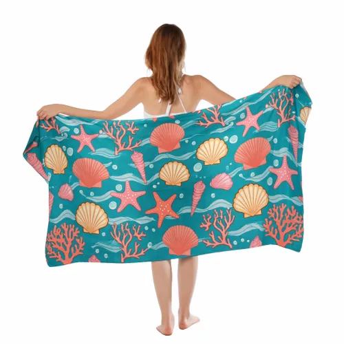 A woman displays a vibrant custom beach towel with bold 'SWIM' text and dynamic graffiti-style designs.